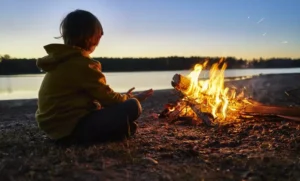 boy watching campfire on spring break trip