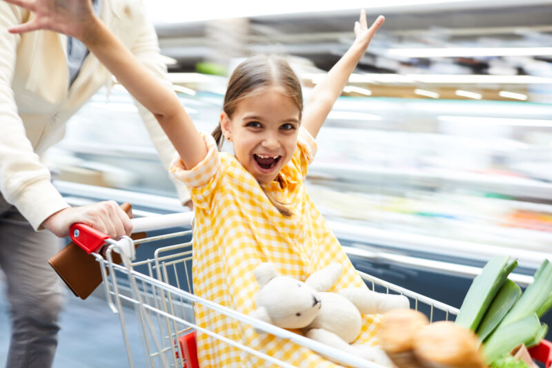 Excited girl riding in shopping cart